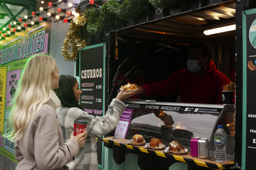 people eating from a food truck