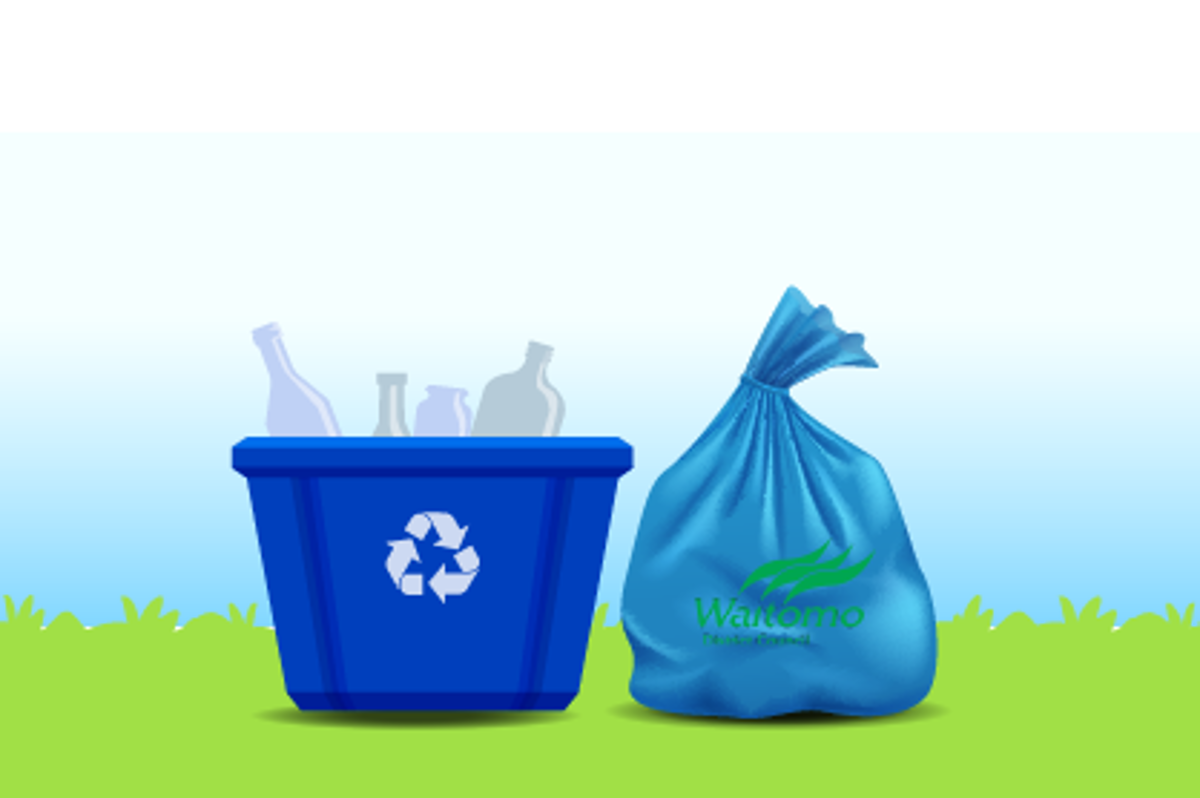 Blue recycling bin and rubbish bag on grass